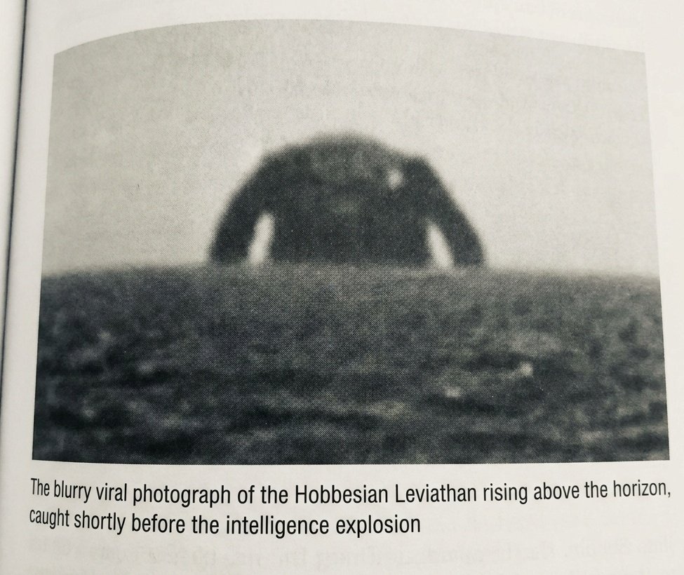 A grainy, black and white photograph shows a dark, blurry, arched shape resembling a torso and arms rising above a flat horizon. Below the image is a caption in a sans-serif font.